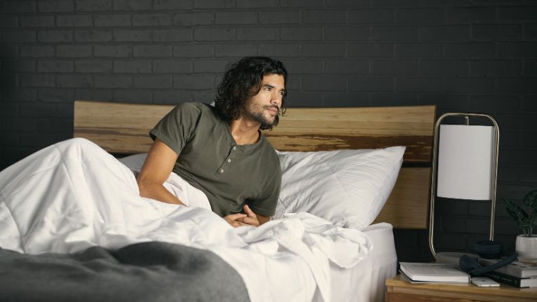 A man on the bed with bedside table