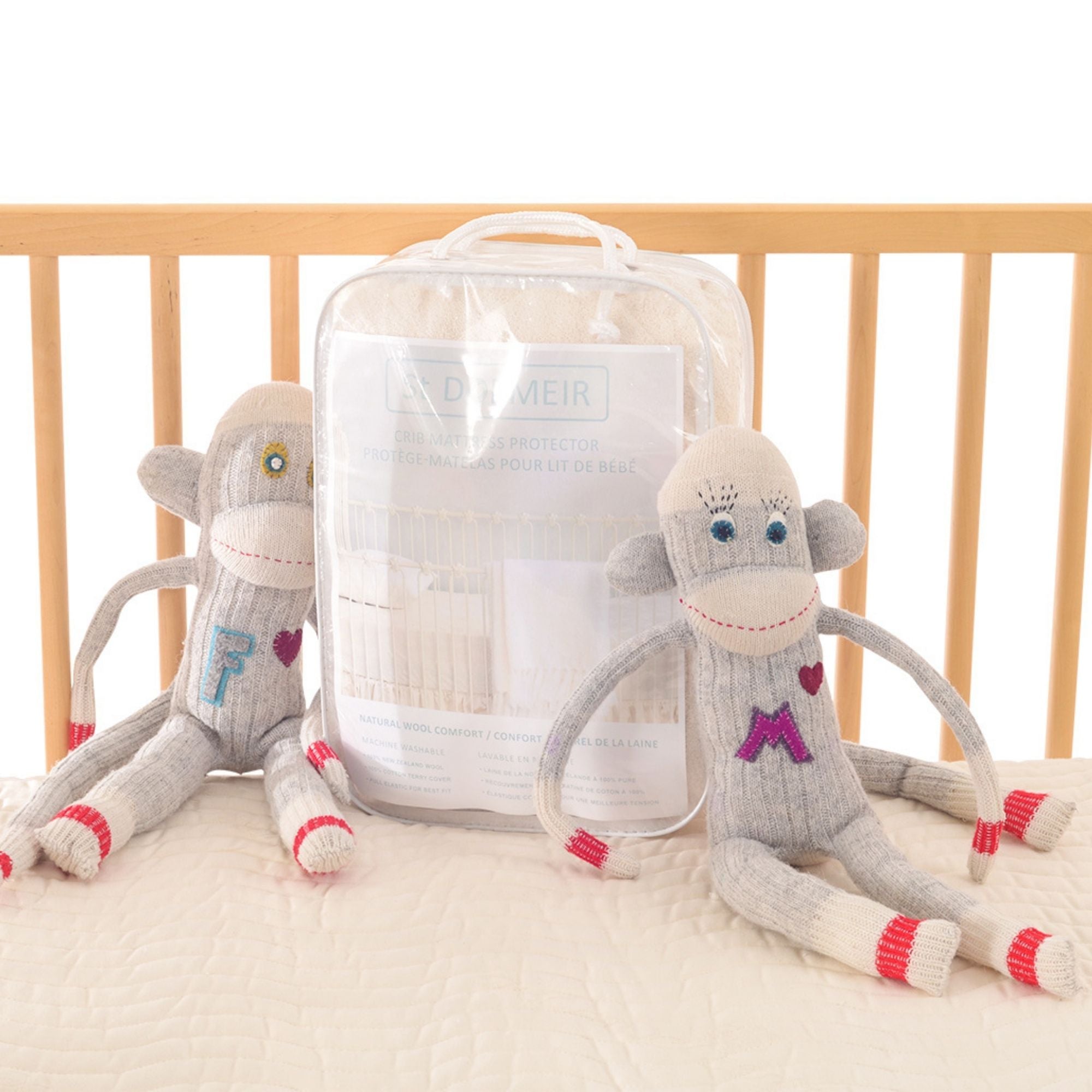 new zealand wool crib mattress protector with stuffed monkeys
