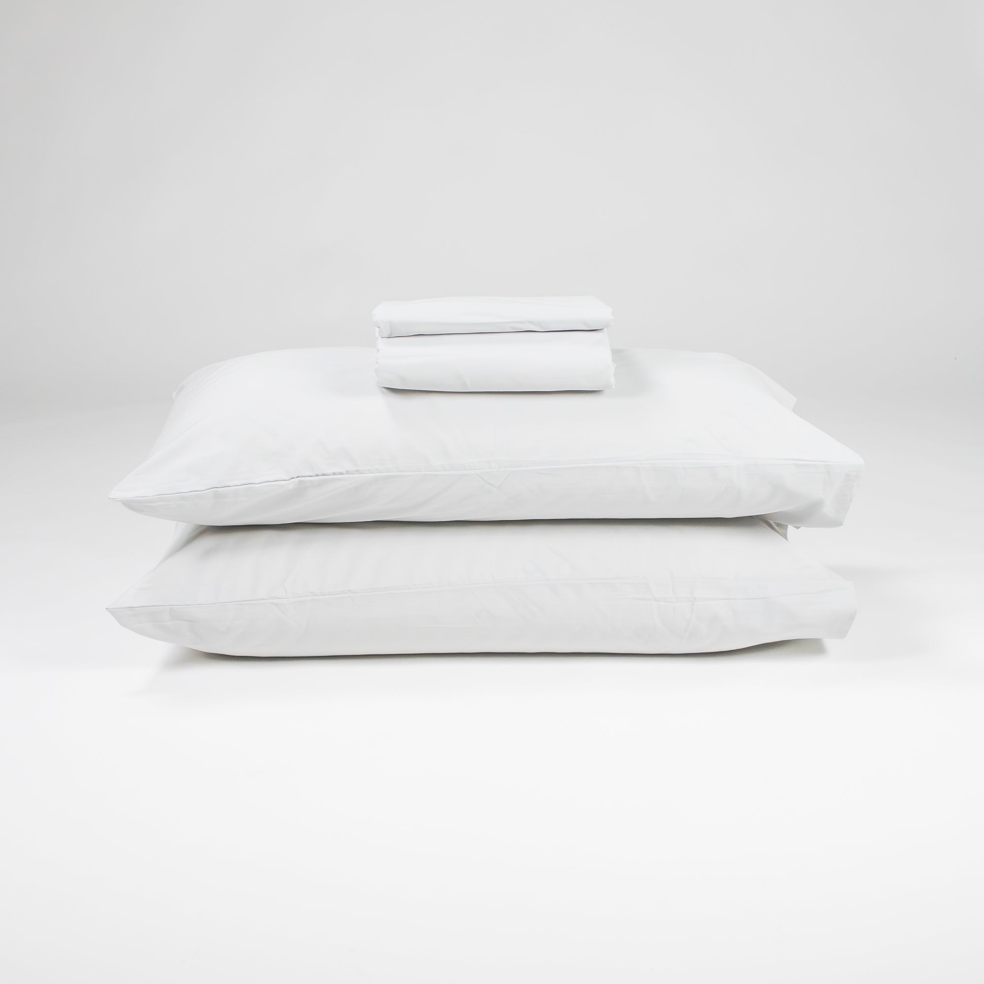 Fawcett Organic Cotton Bed Sheet Set stacked with pillows grey