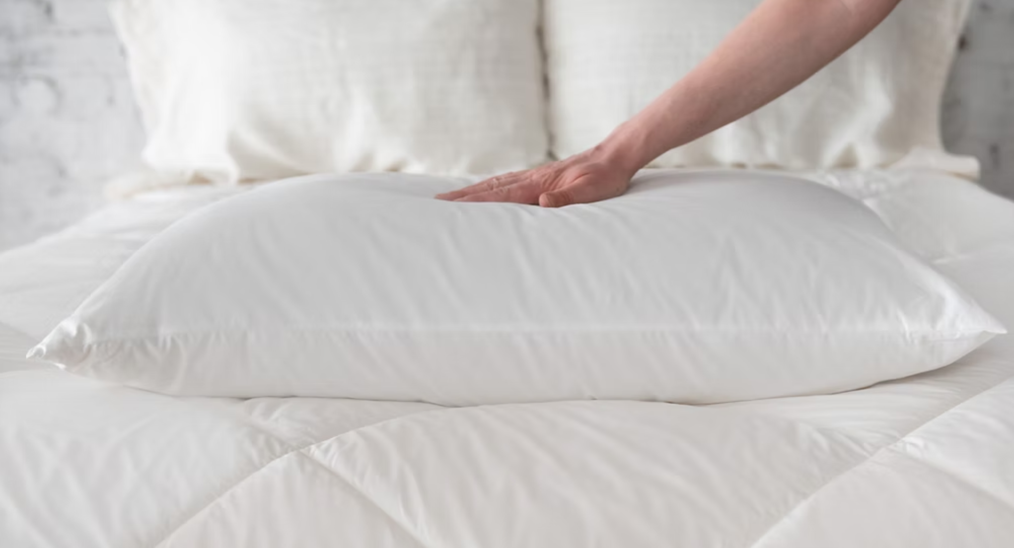 Piatra Wool Pillow hand pressing down on them